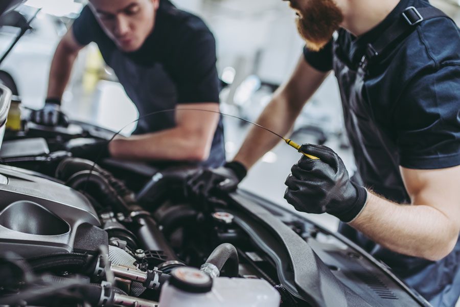 Garage Repair Shop Insurance - Mechanics Changing Oil in the Car